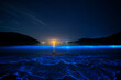 © xx - Bioluminescent glowing waves, known as blue tears, crashing on the beach at night under a starry sky. Long exposure seascape showing the magical phenomenon of glowing plankton.