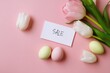 © Iryna - Easter sale card with tulips and pastel eggs on pink background