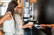 © ADDICTIVE STOCK - Women making hotel payment at reception desk