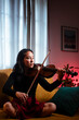 © Ibai Acevedo/Stocksy - Focused woman playing violin at home