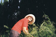 © Eloisa Ramos/Stocksy - Retired Woman smiling while gardening in tall grass