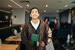 © Pedro Merino/Stocksy - Portrait of an Asian man holding a notebook in a coworking