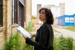 © Studio Sincère/Stocksy - Curious Woman Examines Plans for Urban Development Project