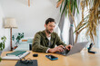 © DZ FILM/Stocksy - A man uses a laptop at home
