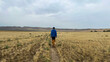 © Angela Tam/Stocksy - Man Walking with Dog on a Path Through a Vast Grassland