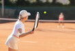 © JackF - Rear view of focused european aged woman playing tennis match in open-air court of tennis club