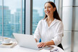 © Artem Podrez/Stocksy - Business Woman Working on Laptop in Modern Office Setting