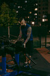 © Vradiy Art/Stocksy - Focused tattooed man exercising outdoors at nighttime