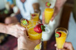 © Holly Clark/Stocksy - Hand toasting a champagne flute full of mimosa
