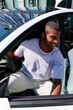© Artem Podrez/Stocksy - Smiling man stepping out of modern white car in sunny city