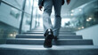 © narumon - The business person is walking up the stairs, symbolizing career advancement.