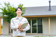 © metamorworks - 笑顔で住宅の前に立つ男性作業員