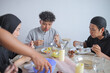 © Gatot - Group Of Asian Muslim Friends Standing And Serving Themselves Food At Family Gathering