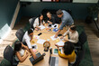 © Rob and Julia Campbell/Stocksy - Collaborative business meeting with diverse team around table