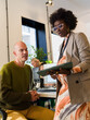 © Milles Team/Stocksy - Businesswoman discussing data with colleague
