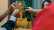 © tirachard - Closeup of Group of multiethnic adult Asia friend drinking alcohol beer bottle glass and having fun laugh enjoy hangout party in night life indoor home. Happy hour millennial generation inside house.