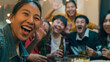 © tirachard - Closeup Group of diversity adult Asia people use phone greeting friend on remote video call hangout party at dining table in night life indoor home. Happy hour millennial generation inside house.