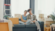 © tirachard - Young happy Asian sweet couple sit on sofa couch smiling looking at camera show proud show off new house keychain in living room. Husband wife move new home, Apartment Rent And Ownership Concept.
