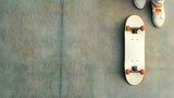 Overhead view of skateboard with orange wheels next to casual sneakers on concrete floor, urban lifestyle and youth culture concept.