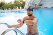© Halfpoint - Male swimmer getting out of the pool after swim training.