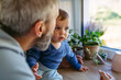 © Halfpoint - Father with little toddler son looking out of window.