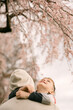© Cavan Images - Boy hugging parent under blooming cherry branches