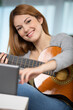 © auremar - young girl playing guitar and recording music in computer