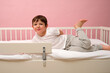 © Андрей Журавлев - Smiling kid boy in pajamas playing on bed with safety rail. Healthy sleep and child development concept for childrens product advertising. Child aged 4 years (four years old)