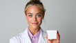 © piai - Professional Female Pharmacist Holding Blank White Medication Box