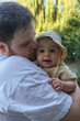© phpetrunina14 - Father Holding Smiling Baby in Park Portrait