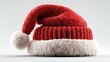 © MdAbulKalam - Playful red Christmas hat with fluffy white trim sitting on a bright background
