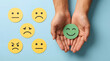 © Gambar - Hands holding happy smiley face icon among sad faces, customer satisfaction concept