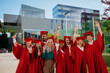 © Halfpoint - Group of cheerful university students with teacher celebrating outdoors, looking at camera, graduation concept.