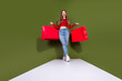 © deagreez - Shopping joy young woman with red bags posing in green studio background