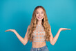 © deagreez - Young woman smiling in a chic checkered top posing against a blue background