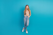 © deagreez - Young chic teen model standing against blue background smiling in casual outfit