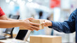 © Puthorn - Customer receives package from courier over counter, signifying successful delivery and streamlined order fulfillment process efficiently today.