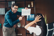 © deagreez - Office drama as a man in blue shirt holds a deadline sign while a stressed colleague watches in a modern loft workspace