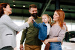 © djile - Family receiving car keys from dealer after purchase