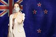 © artmim - Confident woman in medical mask showing stop gesture open palm hand against flag of New Zealand background