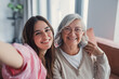 © Daniel - Head shot portrait happy woman with mature mother taking selfie on smartphone together, looking at camera, smiling senior mom and excited grown-up daughter having fun with camera, recording video