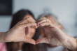 © Daniel - Portrait of happy elderly Caucasian mother and adult daughter make heart love hand gesture or sign together. Self-portrait picture of smiling adult kid child with mature mom show unity and bonding