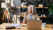 © InsideCreativeHouse - Middle-age woman using laptop computer for business studying, having videocall with online virtual webinar training meeting, writing notes. Focused businesswoman working in office. Copy space