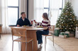 © Богдан Маліцький - young couple is having dinner at home at the table on New Year's Eve, woman and man are celebrating Christmas and eating and drinking wine