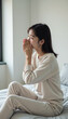 © AlenaSi - Woman sitting on bed expressing emotions in bright room, hands covering face in moment of reflection. Emotional state depicted in cozy atmosphere,