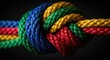 © Sinta - Close up of a colorful knotted rope on black background conceptual design