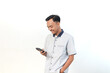 © Rifqi Muflih - Asian man wearing a shirt with a smiling expression is holding a smartphone on an isolated white background.
