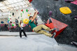 © Alvaro Lavin/Stocksy - Man bouldering at indoor climbing gym, woman watching