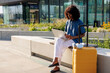 © Artem Podrez/Stocksy - Stylish Female Traveler Remote Work Setup with Yellow Suitcase