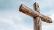 © Iuliia - Old wooden cross against a light blue sky. Religious symbol of faith, sacrifice, and redemption. Christianity and spiritual concept for Easter.